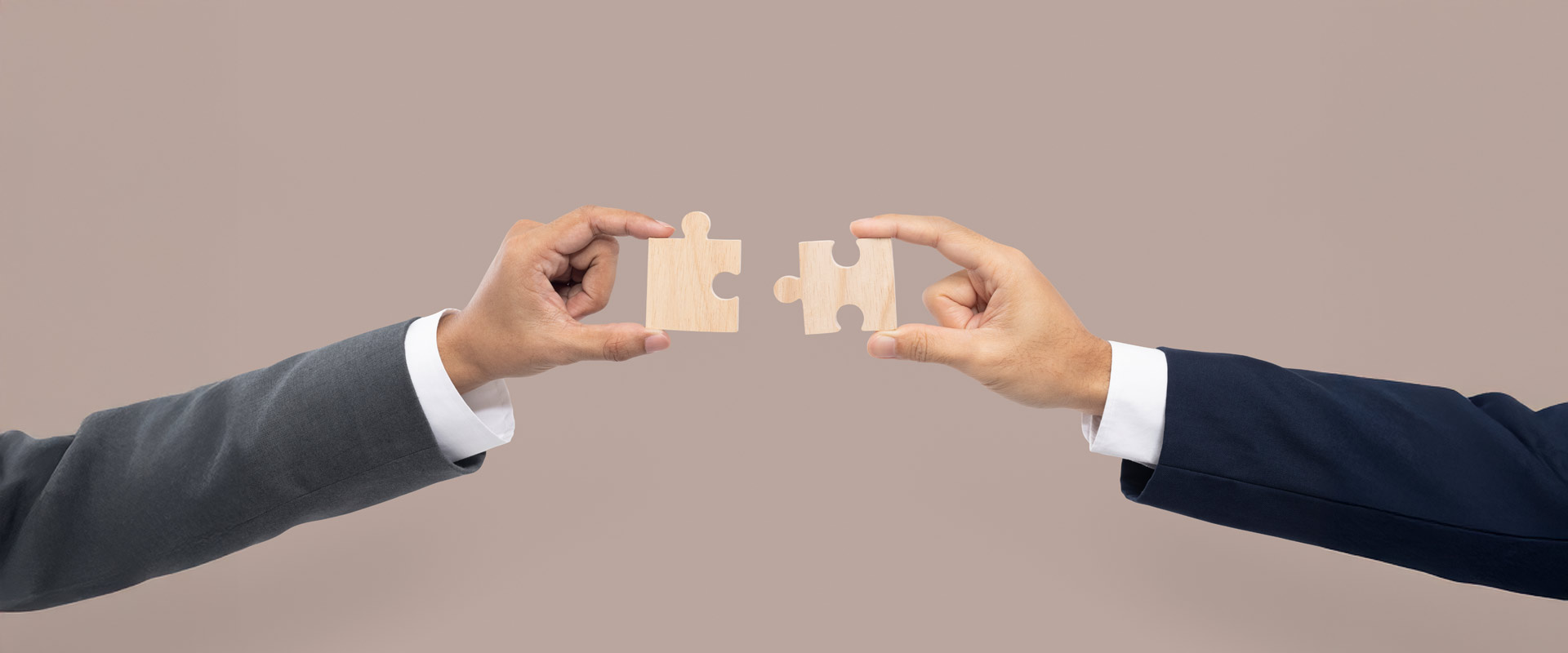 An image which represents two pieces of puzzle being joined, symbolizing strategic partnerships