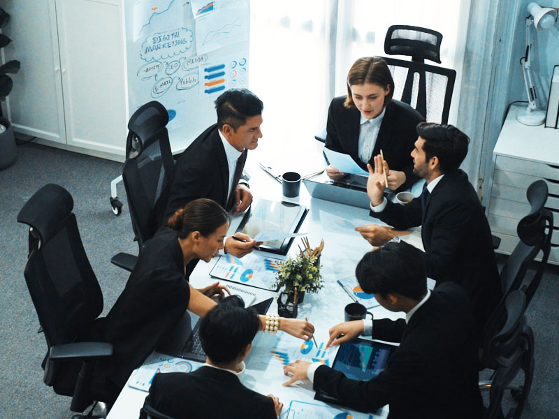 people sitting around a table wearing suits and discussing
