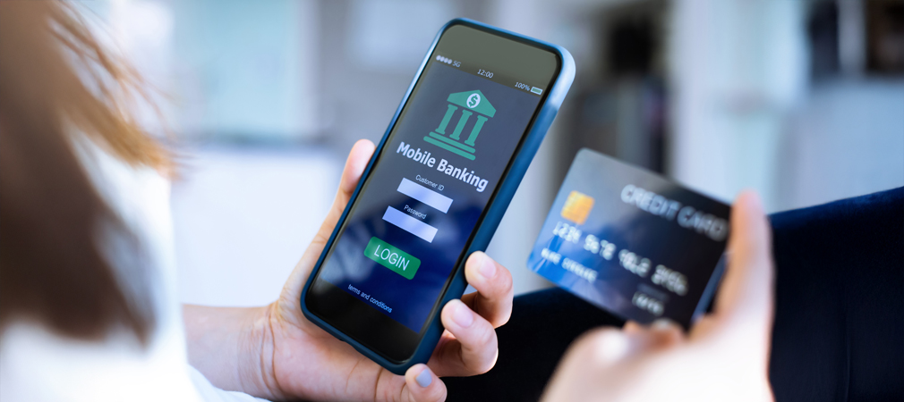 Image of a person holding a phone with the image representing digital banking on the device